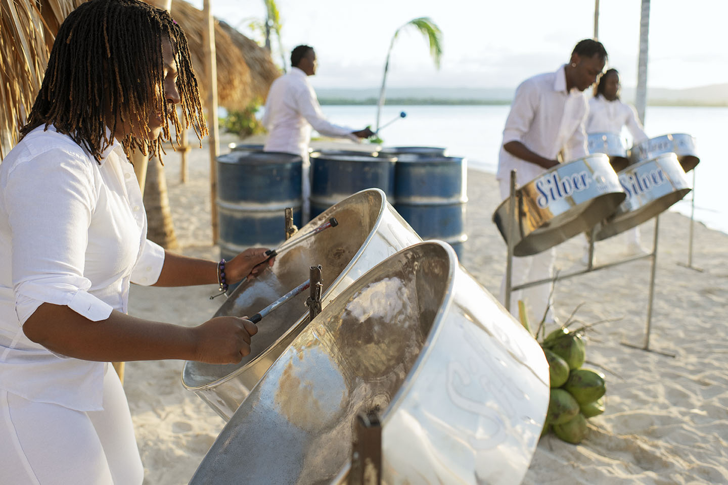 Woman playing steelpan drums on a beach in Jamaica