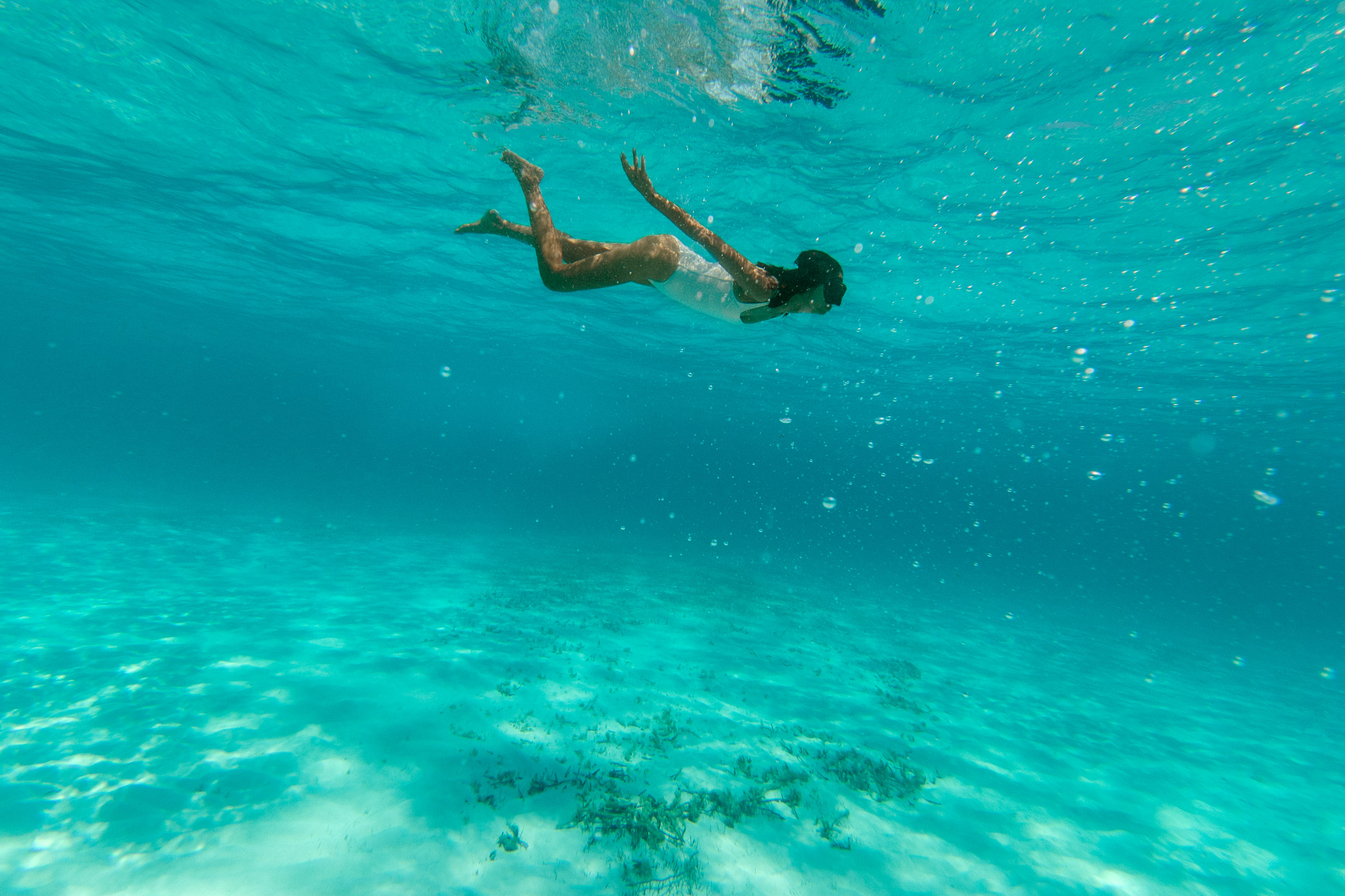 Female solo traveler swimming in the ocean alone