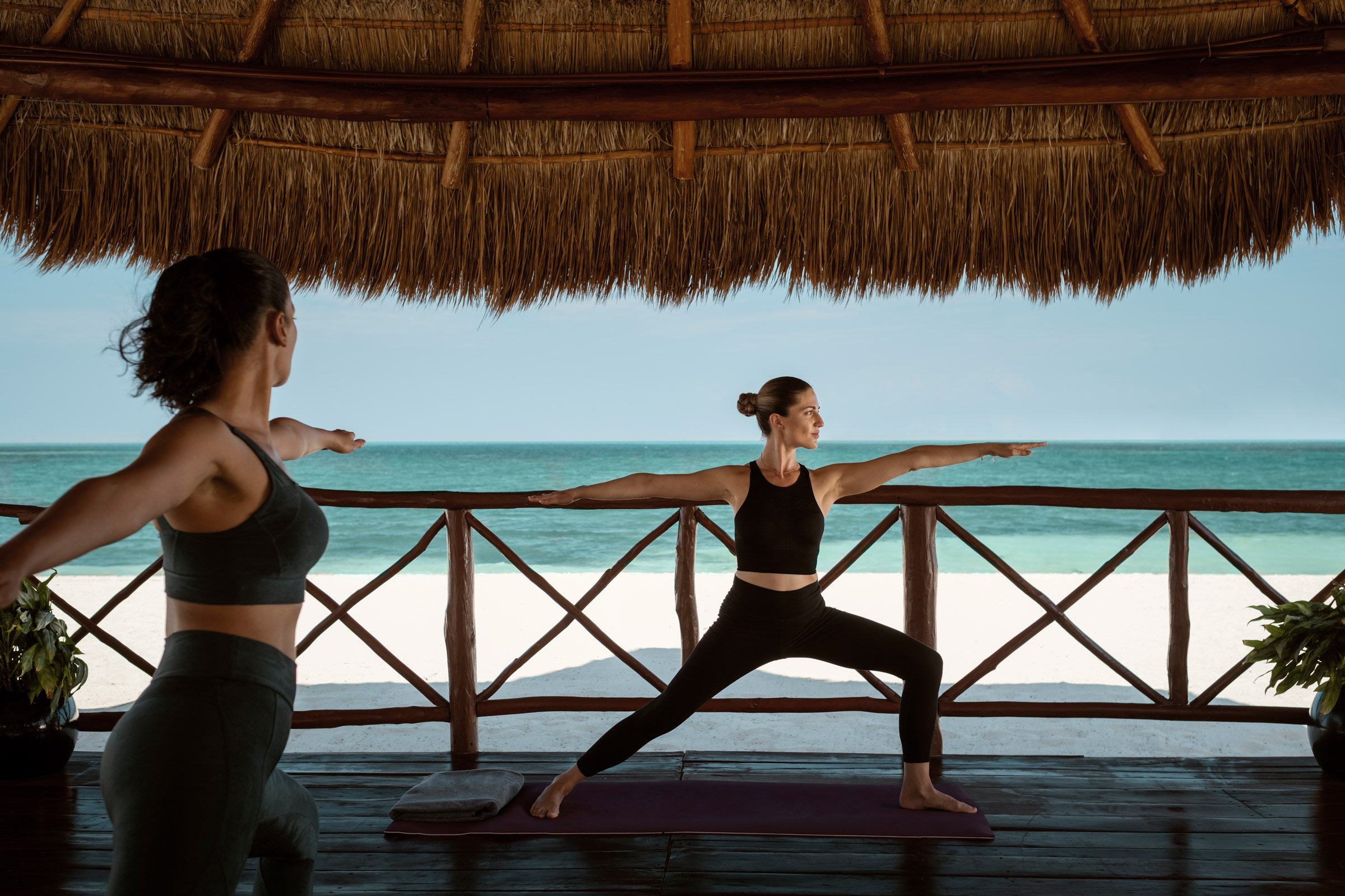 Woman doing yoga by the beach on vacation Woman doing yoga by the beach on vacation